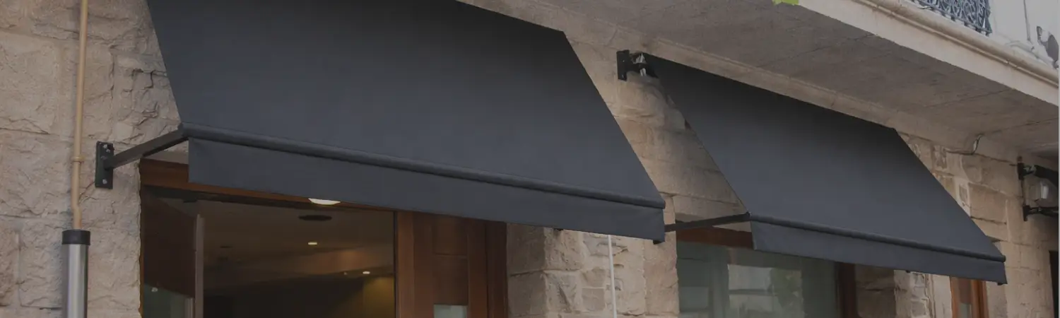 Toldo de lona gris sobre el frente de piedra de un edificio