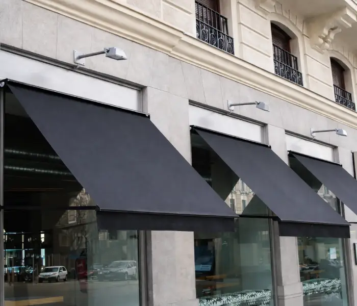 Toldos de lona negra sobre las ventanas de un edificio