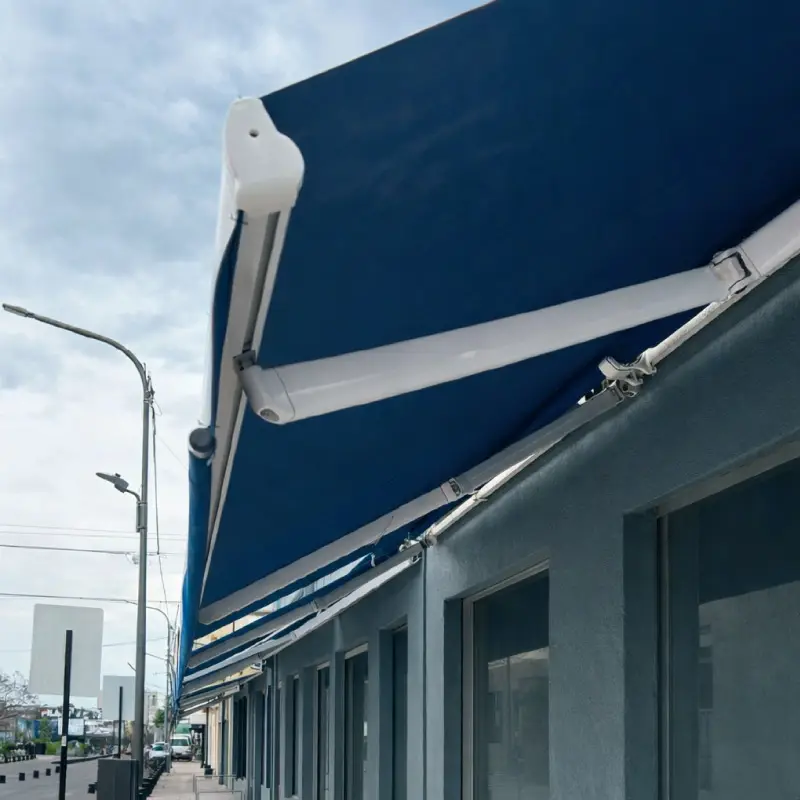 Toldo de brazo invisible azul extendido sobre el frente de un comercio